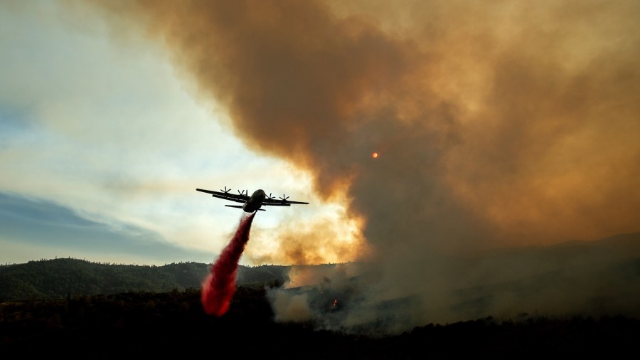 An air tanker drops retardant on the Ranch Fire, part of the Mendocino Complex Fire, burning near Clearlake Oaks, Calif., on Aug. 5, 2018. (Credit: NOAH BERGER/AFP/Getty Images)