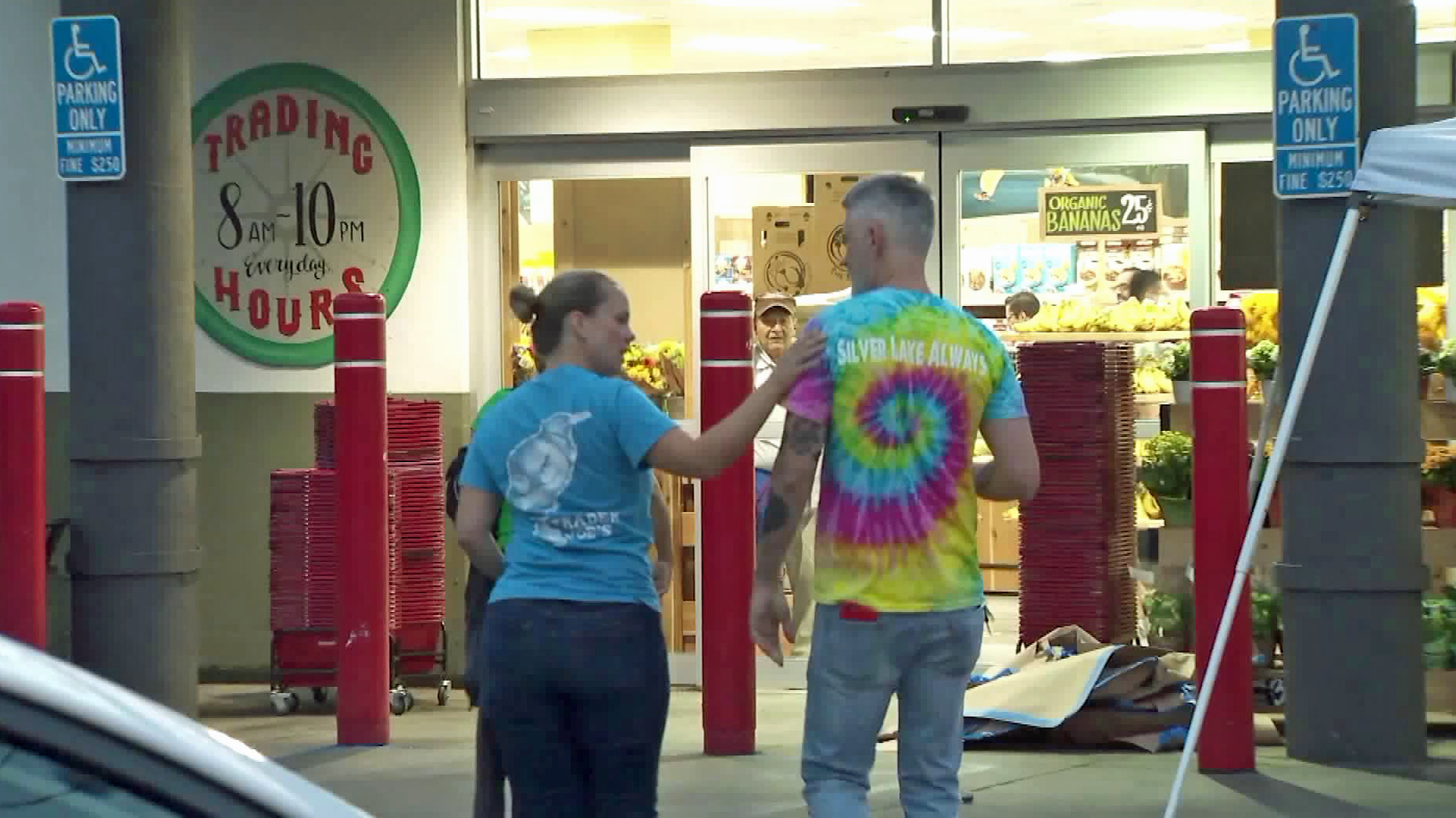 Two Trader Joe's employees embrace before walking into the Silver Lake store on Aug. 2, 2018. (Credit: KTLA)