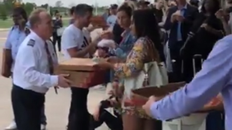 A captain brings pizza to passengers stranded in Texas. (Credit: @J_reigns2)