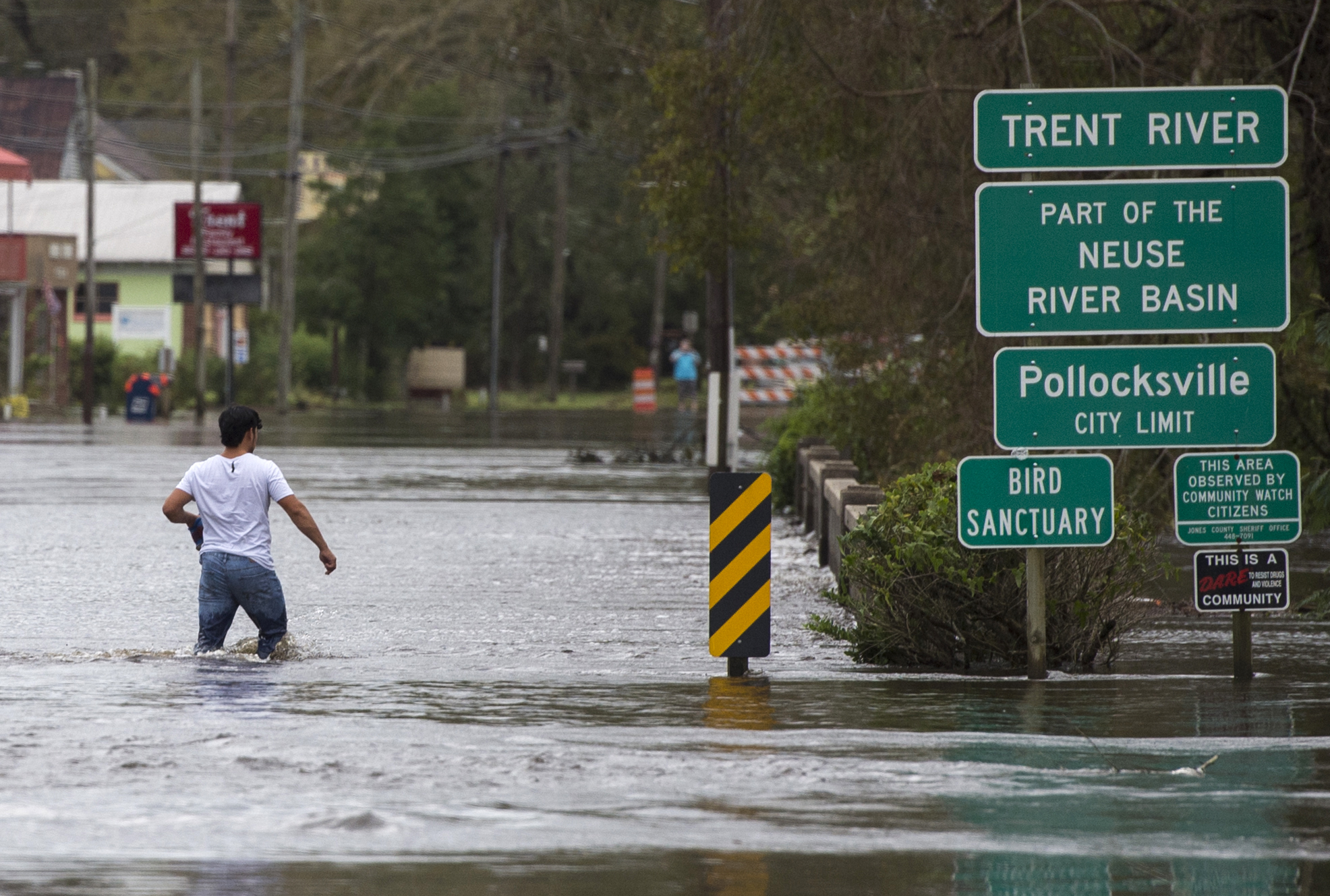 A man wades across a bridge flooded by Hurricane Florence in Pollocksville, North Carolina, on September 16, 2018. (Credit: ANDREW CABALLERO-REYNOLDS/AFP/Getty Images)