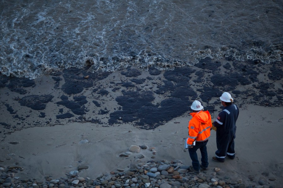 Officials walk along Refugio State Beach on May 19, 2015 north of Goleta. (Credit: David McNew/Getty Images)