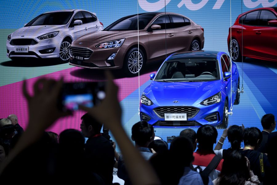 Visitors look at a display for the new Ford Focus at the Beijing auto show in Beijing on April 25, 2018. (Credit: WANG ZHAO/AFP/Getty Images)