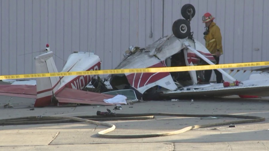 A fire official inspects the damage of a small plane crash at Whiteman Airport on Sept. 3, 2018. (Credit: KTLA)