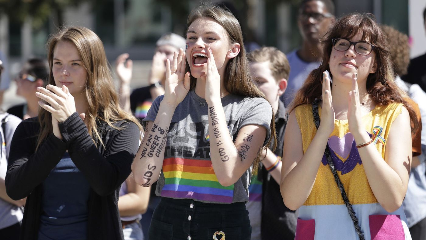 Azusa Pacific University students Alissa Gmyrek, Cayla Hailwood and Rachel Davis cheer on speakers during an LBGTQ support rally at the college on Oct. 1, 2018. (Credit: Myung J. Chun / Los Angeles Times)