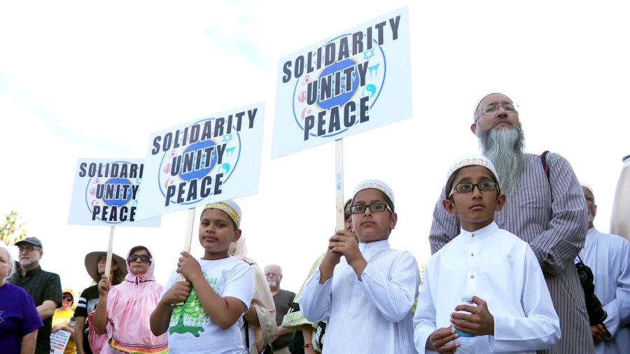 Children are seen holding signs at an interfaith march in Woodland Hills on Oct. 28, 2018, a day after a man launched a deadly attack on a synagogue in Pittsburgh. (Credit: KTLA)