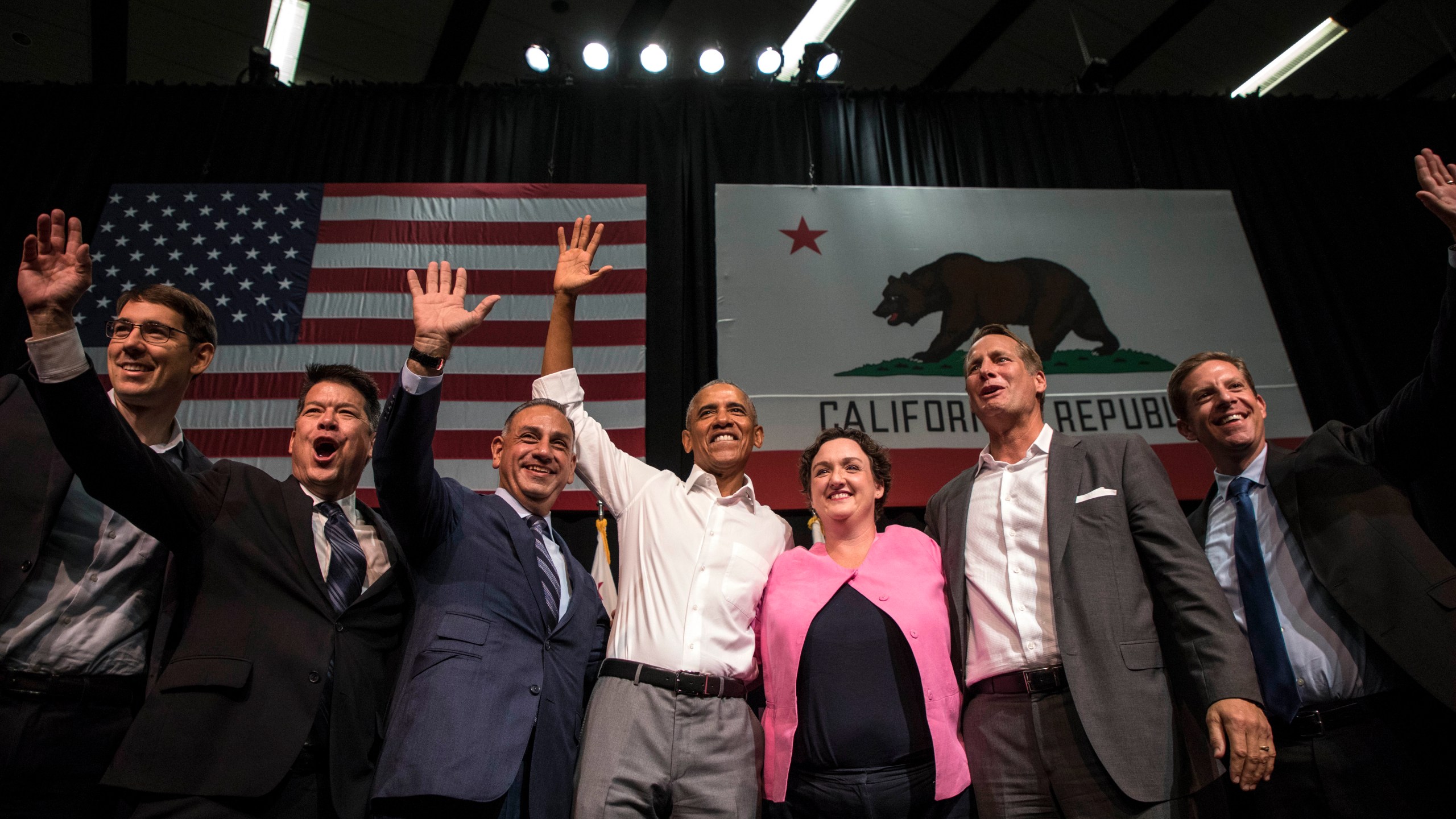 From left to right, Josh Harder, TJ Cox, Gil Cisneros, former U.S. President Barack Obama, Katie Porter, Harley Rouda, and Mike Levin wave to supporters during a congressional candidates rally at the Anaheim Convention Center on Sept. 8, 2018. (Credit: Barbara Davidson/Getty Images)