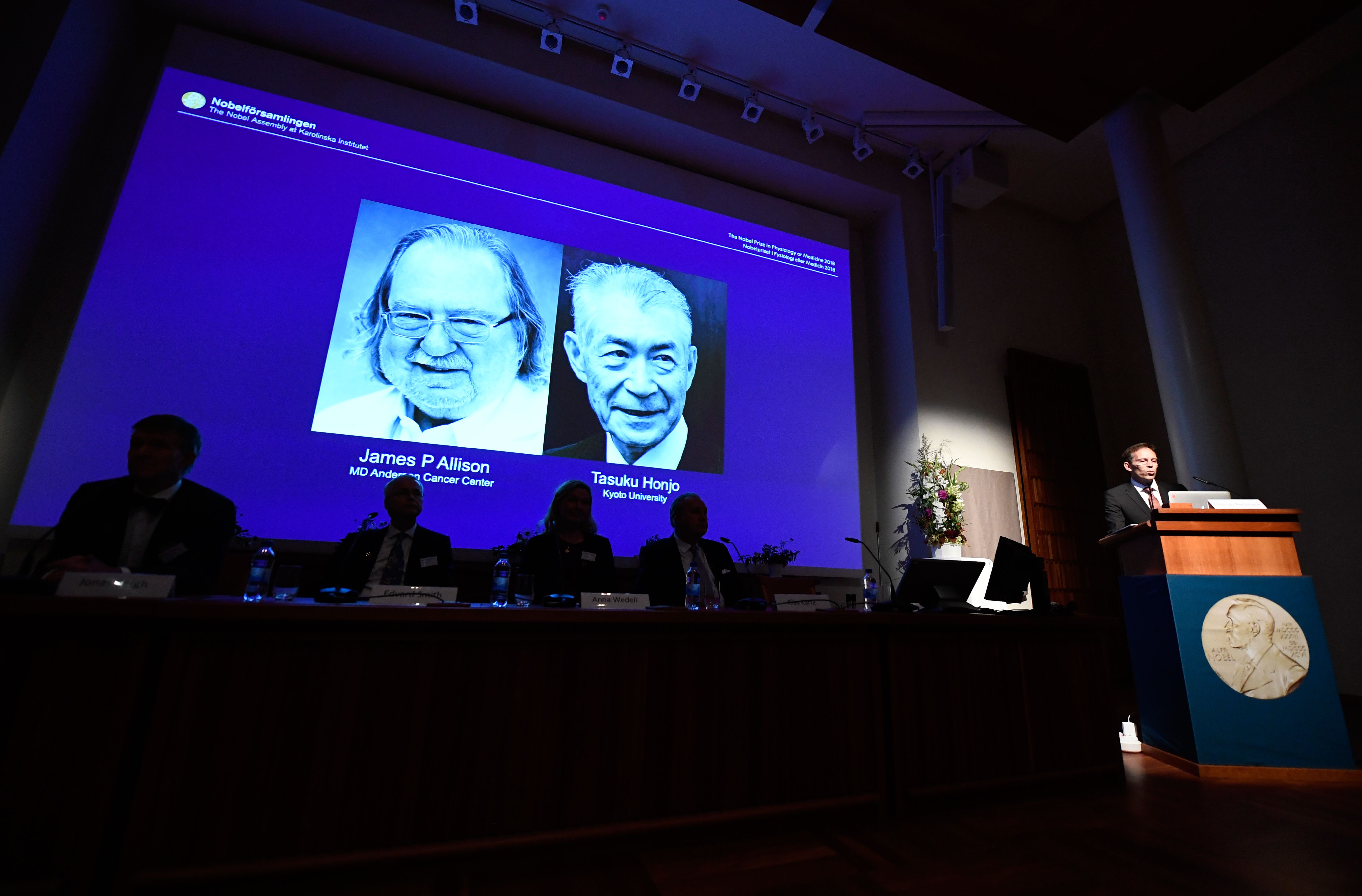 Secretary of the Nobel Committee for Physiology or Medicine, Thomas Perlmann (right) announces the winners of the 2018 Nobel Prize in Physiology or Medicine during a press conference at the Karolinska Institute in Stockholm, Sweden, on Oct. 1, 2018. (Credit: Jonathan Nackstrand/AFP/Getty Images)