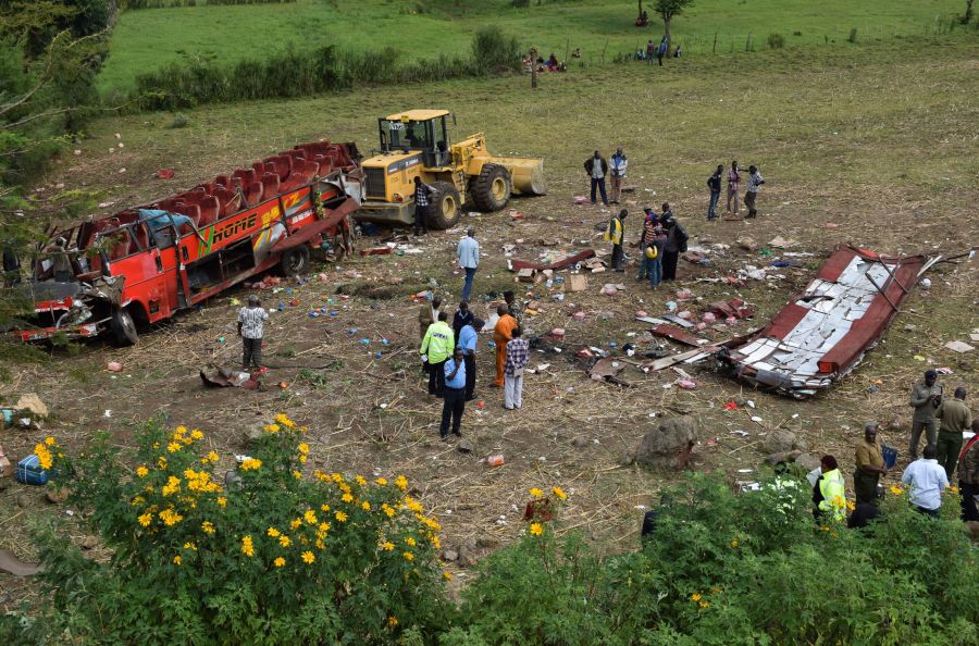 Kenyan emergency personnel and security forces inspect the wreckage of a bus at the site of an accident in Kericho, western Kenya, on October 10, 2018. (Credit: Brian Ongoro/AFP/Getty Images)