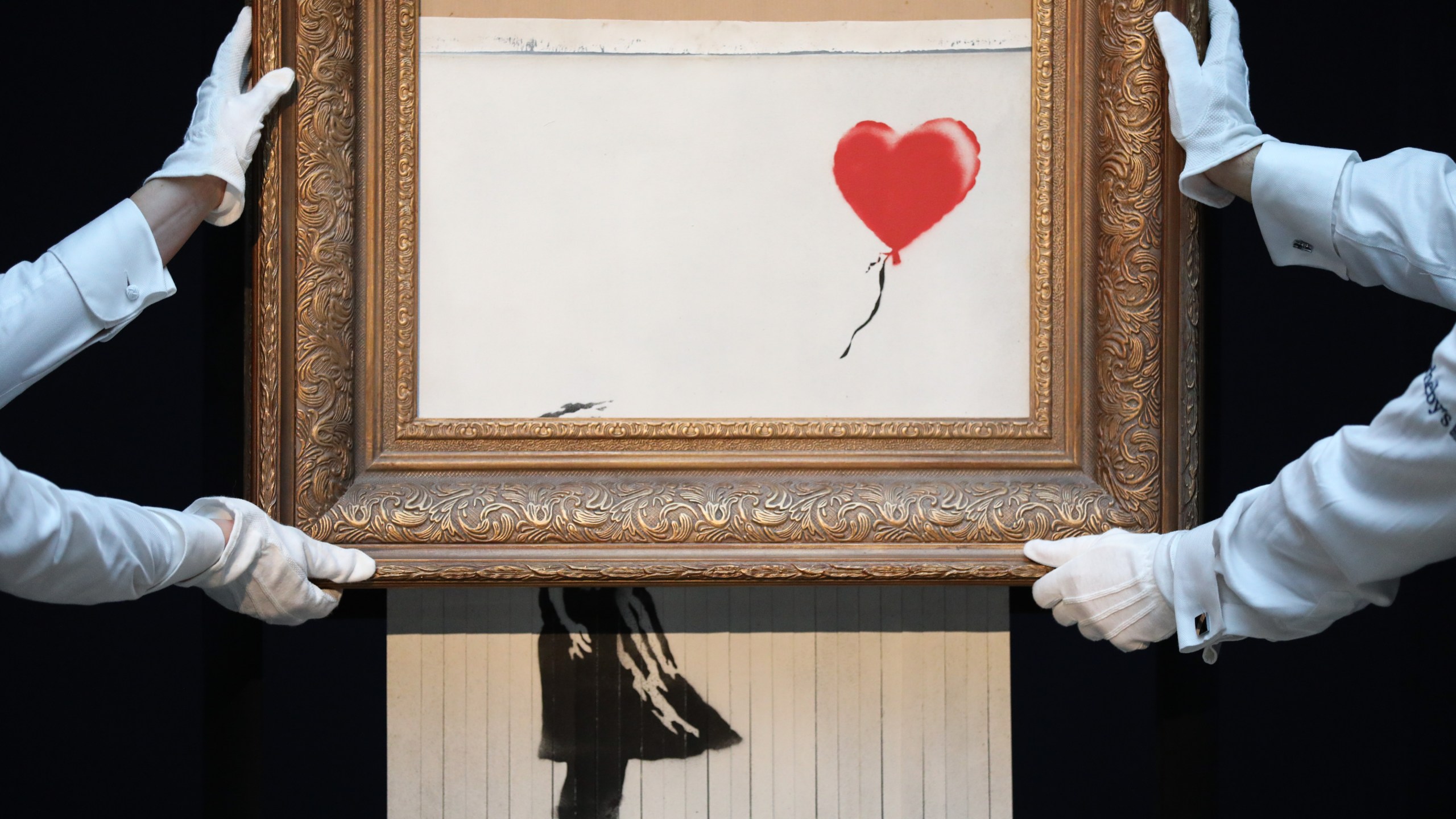 Sotheby’s unveils Banksy’s newly-titled "Love is in the Bin" at Sotheby's in London on Oct. 12, 2018. Originally titled "Girl with Balloon," the canvas passed through a hidden shredder seconds after the hammer fell at Sotheby’s London Contemporary Art Evening Sale on Oct. 5, 2018, making it the first artwork in history to have been created live during an auction. (Credit: Tristan Fewings / Getty Images for Sotheby's)