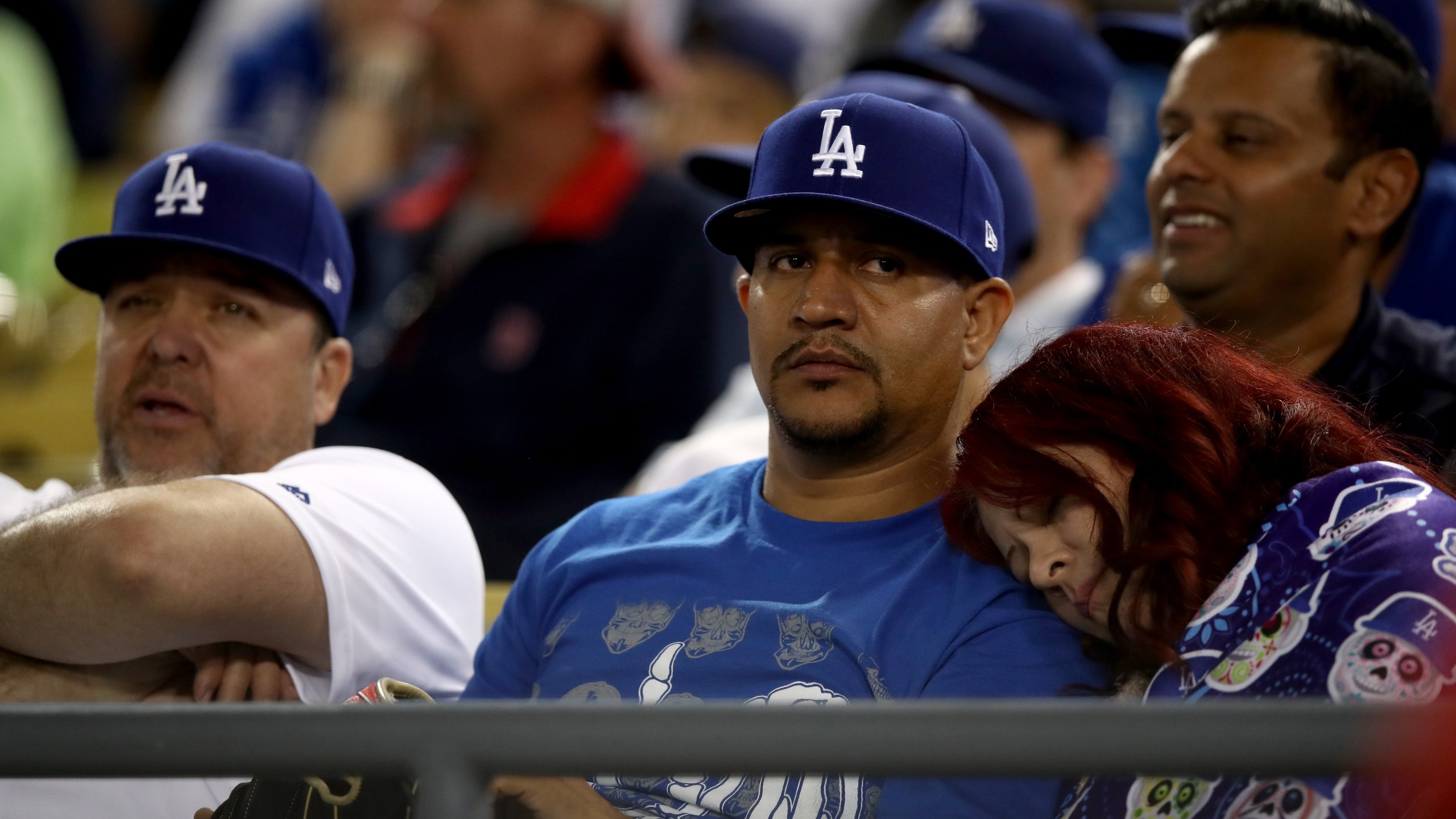 A fan rests during the 17th inning in Game 3 of the 2018 World Series between the Los Angeles Dodgers and the Boston Red Sox at Dodger Stadium on Oct. 26, 2018. (Credit: Ezra Shaw/Getty Images)