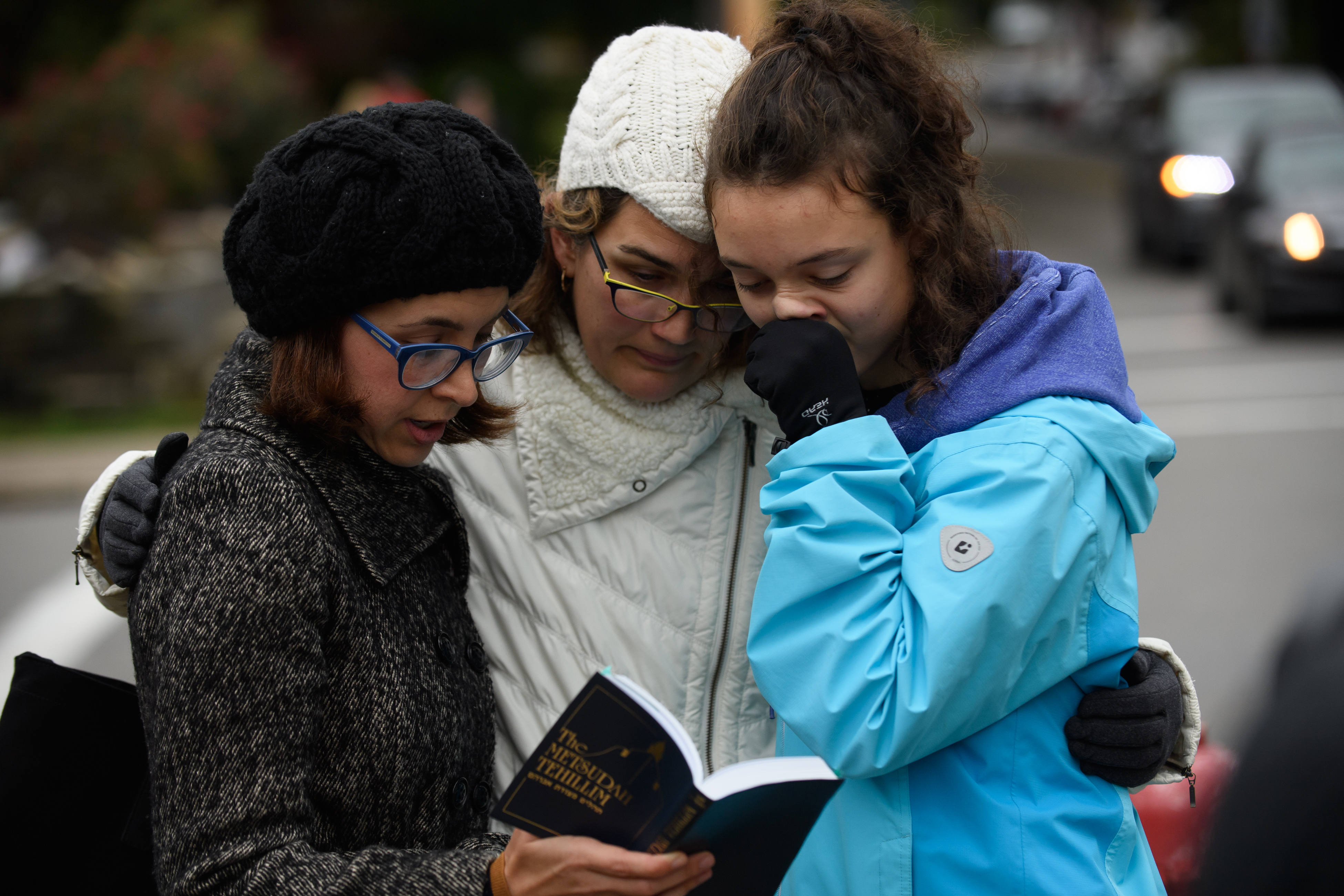 Tammy Hepps, Kate Rothstein and her daughter, Simone Rothstein, 16, pray from a prayerbook a block away from the site of a mass shooting at the Tree of Life Synagogue in the Squirrel Hill neighborhood on Oct. 27, 2018 in Pittsburgh, Pennsylvania. (Credit: Jeff Swensen/Getty Images)