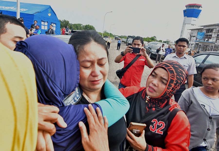 Putri (C), is consoled for the loss of her husband and child who were passengers on board the ill-fated Lion Air flight JT 610, in Pangkal Pinang airport in Bangka Belitung province on October 29, 2018. (Credit: RONI BAYU/AFP/Getty Images)