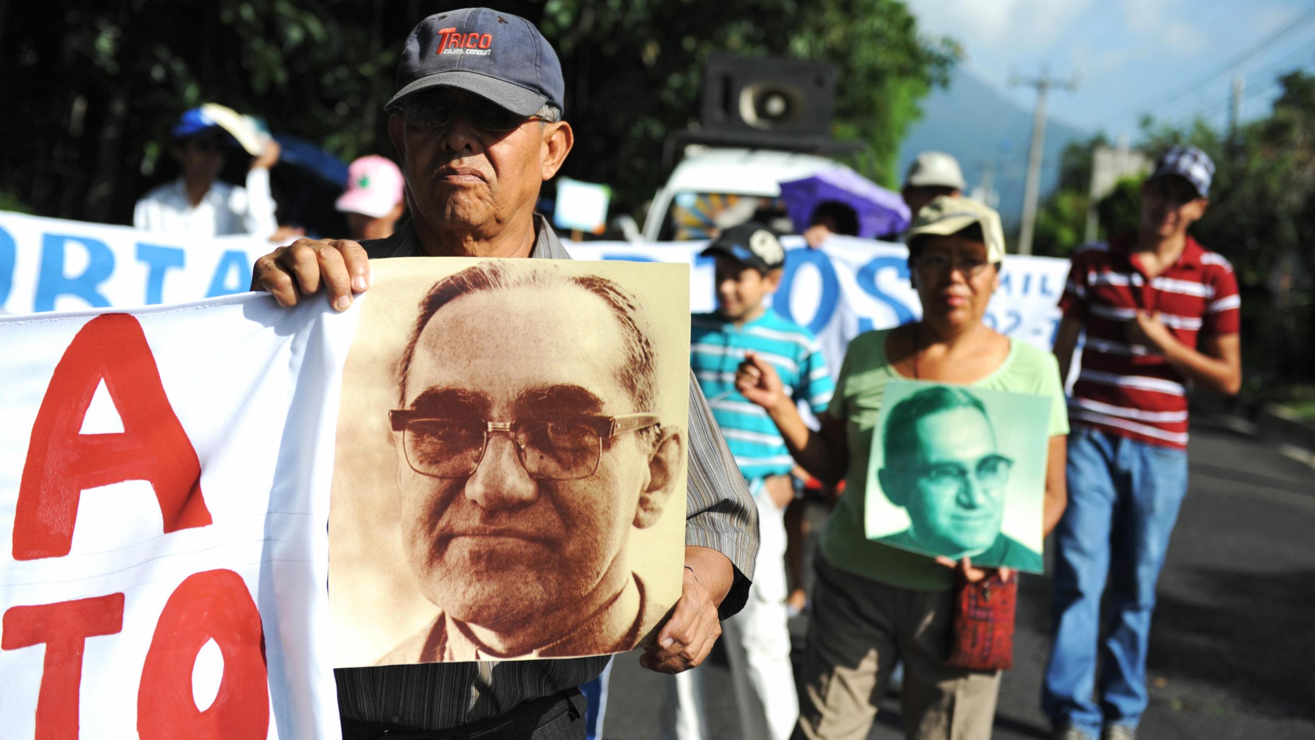 Catholic faithfuls participate in a march to celebrate the 92nd birthday of the late archbishop of San Salvador, Oscar Arnulfo Romero, carrying signs and pictures portraying him, in San Salvador on Aug. 15, 2009.(Credit: Jose CABEZAS/AFP/Getty Images)