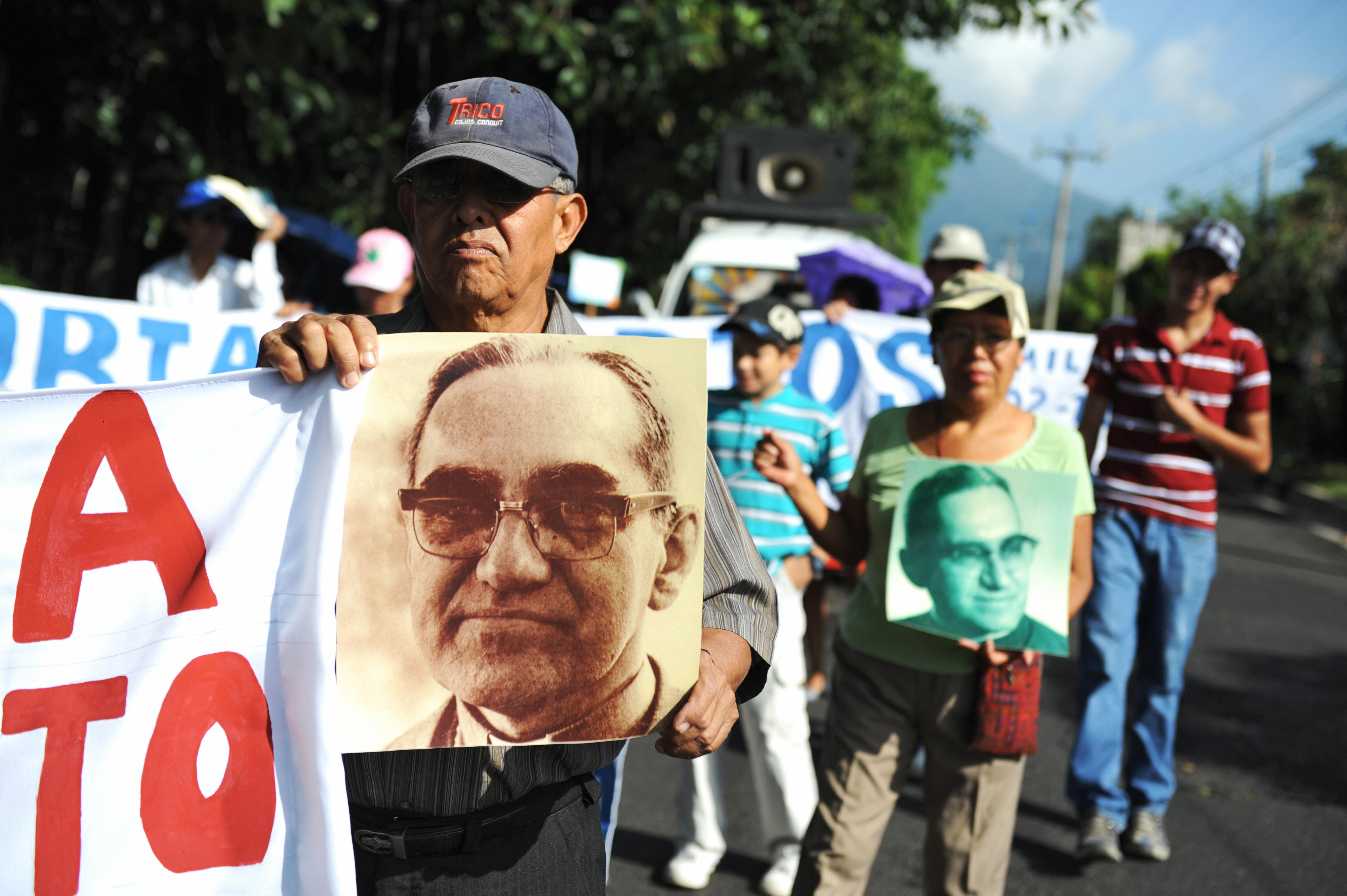 Catholic faithfuls participate in a march to celebrate the 92nd birthday of the late archbishop of San Salvador, Oscar Arnulfo Romero, carrying signs and pictures portraying him, in San Salvador on Aug. 15, 2009.(Credit: Jose CABEZAS/AFP/Getty Images)