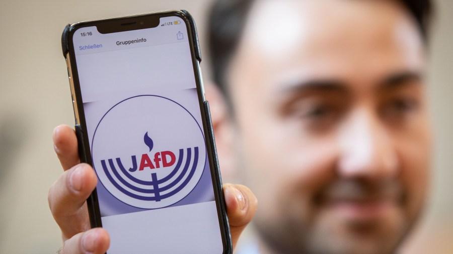 Committee member Leon Hakobian shows on his mobile phone a preliminary draft of a logo for a new Jewish grouping within Germany's far-right AfD party during the group's founding event on Oct. 7, 2018, in Wiesbaden, western Germany. (Credit: FRANK RUMPENHORST/AFP/Getty Images)