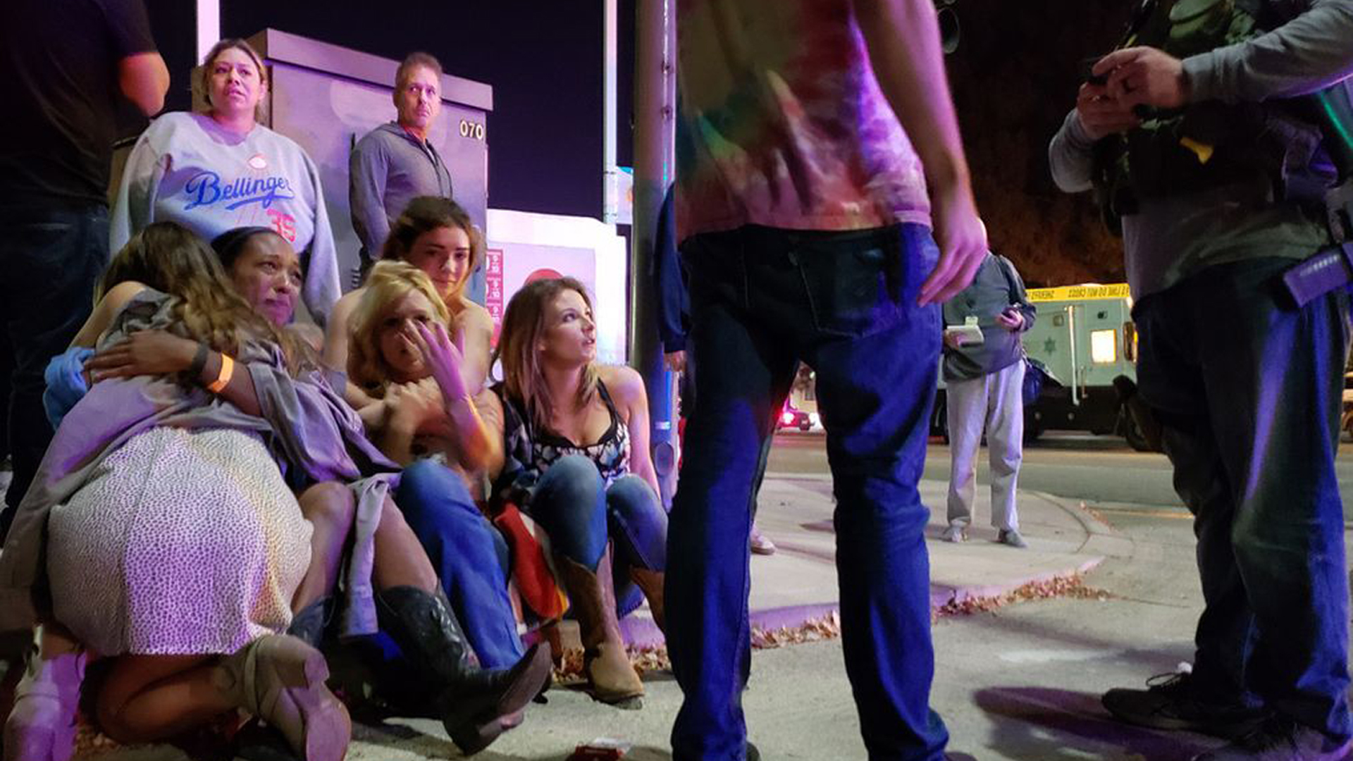 Witnesses console one another across the street from the Borderline Bar & Grill and talk to law enforcement. (Credit: Sean Greene / Los Angeles Times)