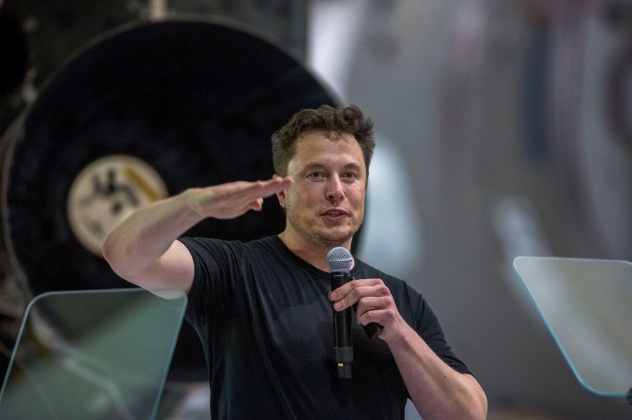 Elon Musk speaks near a Falcon 9 rocket during his announcement that Japanese billionaire Yusaku Maezawa will be SpaceX's first private passenger to fly around the Moon at the company's Hawthorne headquarters on Sept. 17, 2018. (Credit: David McNew / AFP / Getty Images)