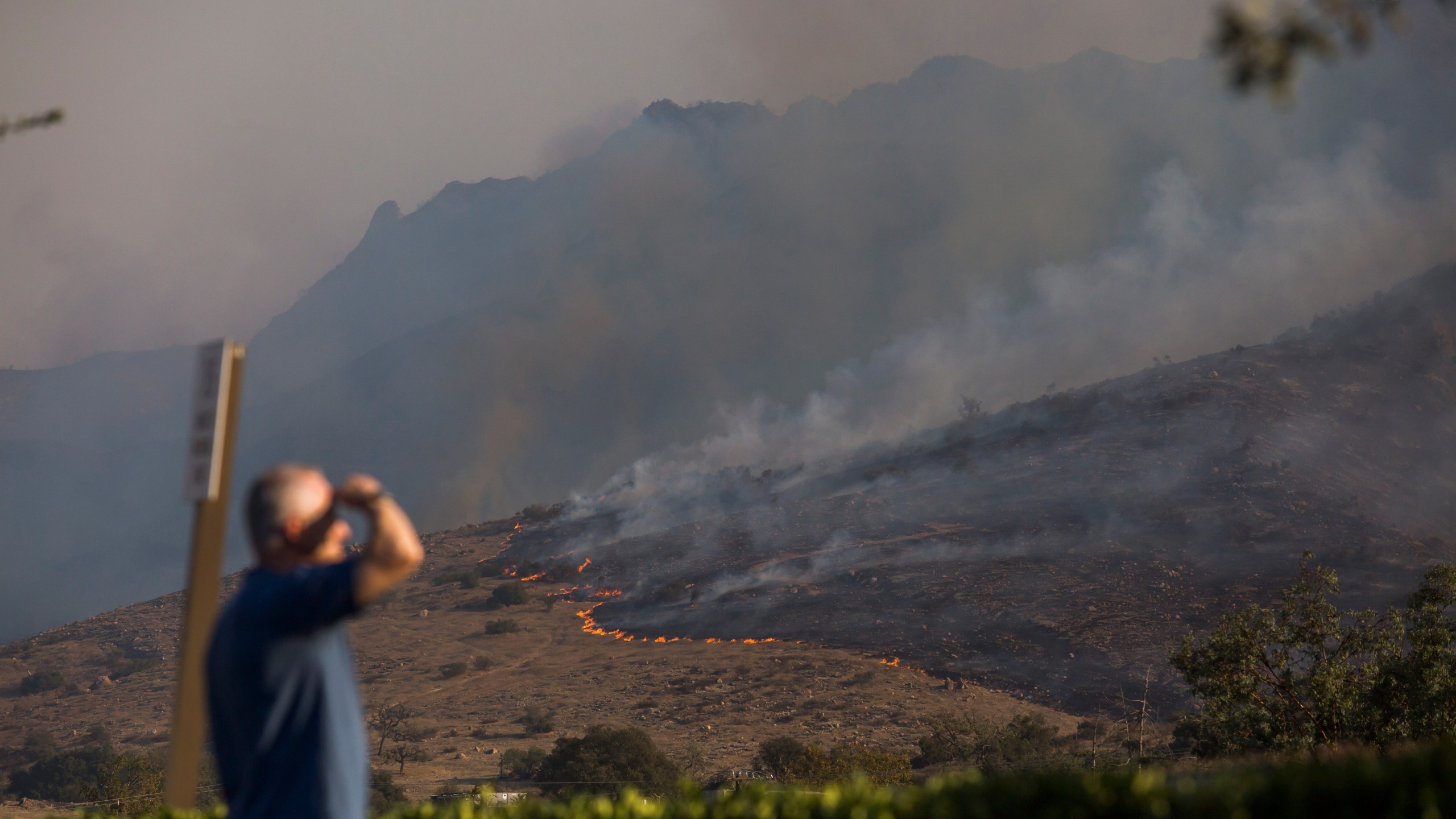 People are looking towards the hills scorched from the wildfires close to the 101 Freeway in Thousands Oaks, California on November 09, 2018. (Credit: APU GOMES/AFP/Getty Images)