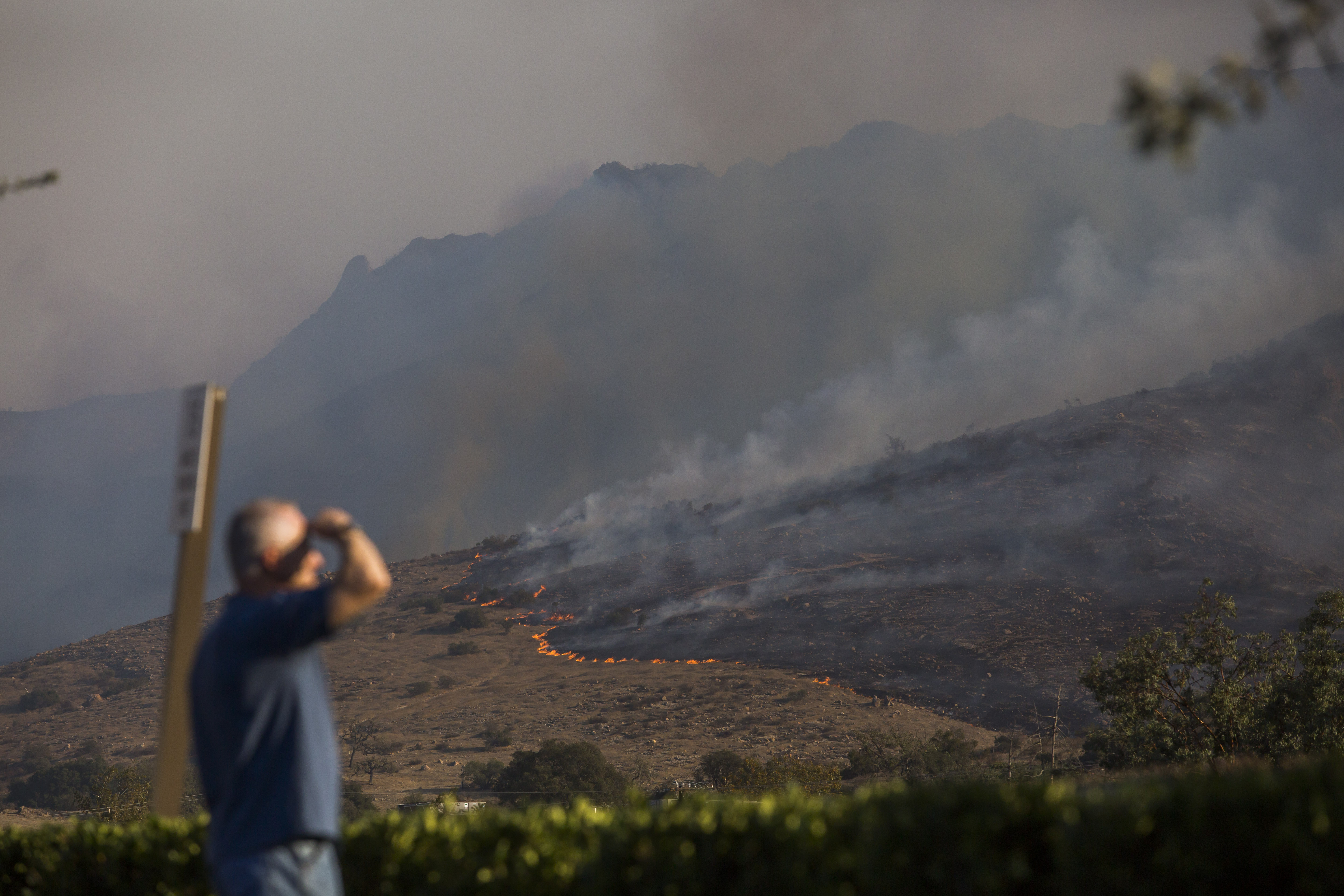 People are looking towards the hills scorched from the wildfires close to the 101 Freeway in Thousands Oaks, California on November 09, 2018. (Credit: APU GOMES/AFP/Getty Images)