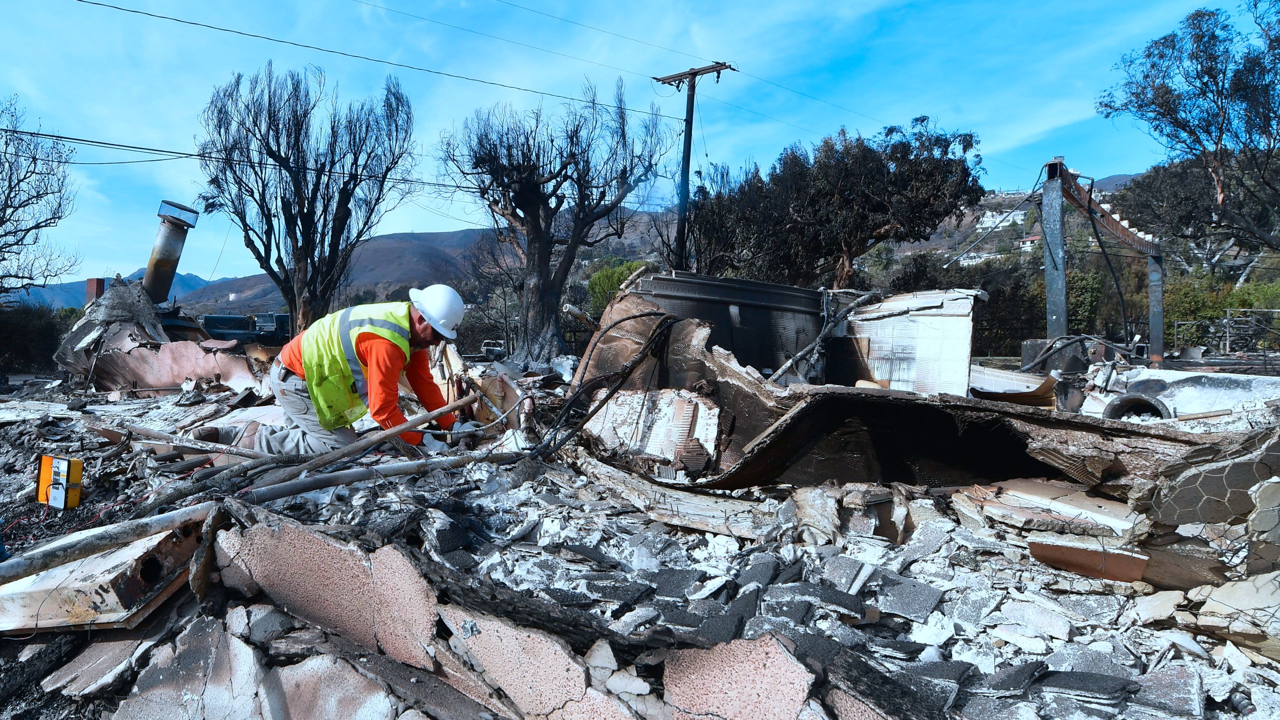 A worker checks gas lines amid the rubble of a home burnt down in the Woolsey Fire on Filaree Heights Road in Malibu on Nov. 13, 2018. (Credit: Frederic J. Brown/AFP/Getty Images)