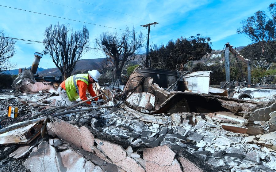 A worker checks gas lines amid the rubble of a home burnt down in the Woolsey Fire on Filaree Heights Road in Malibu on Nov. 13, 2018. (Credit: Frederic J. Brown/AFP/Getty Images)