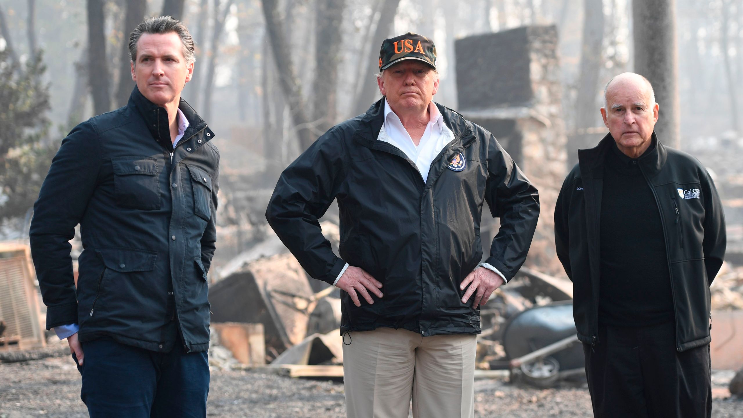 Donald Trump stands alongside Gov. Jerry Brown and Gov.-elect Gavin Newsom as they view damage from the Camp Fire in Paradise, California on Nov. 17, 2018. (SAUL LOEB/AFP/Getty Images)