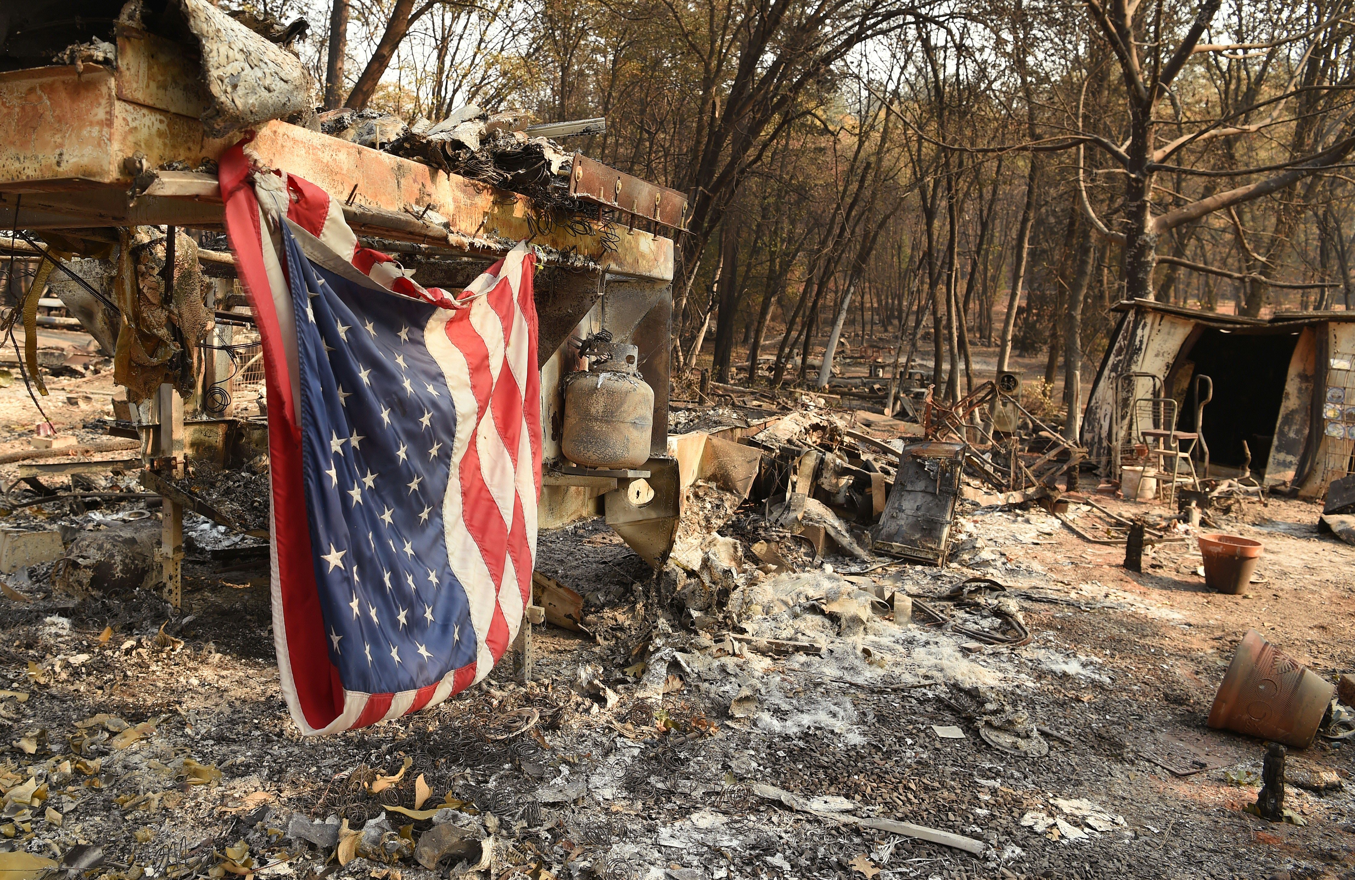 An American flag hangs at a burned out mobile home park in Paradise, California on Nov. 18, 2018. (Credit: Josh Edelson/AFP/Getty Images)