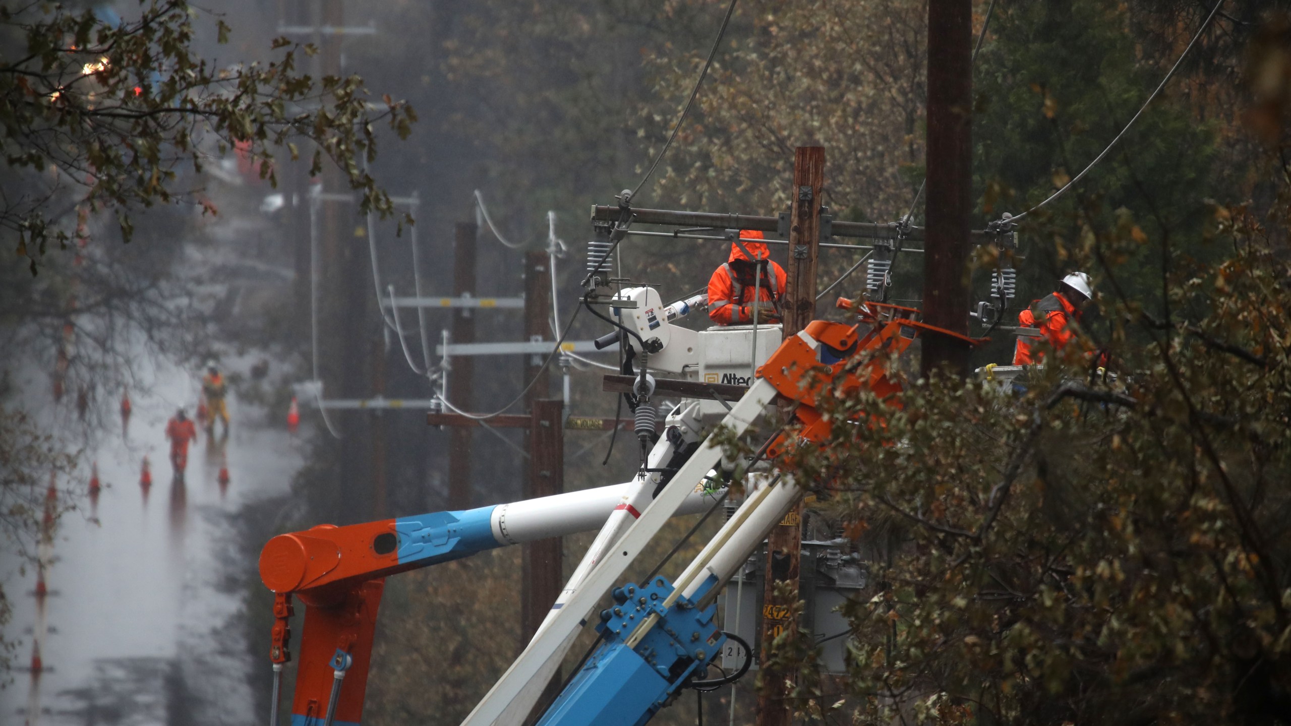 Pacific Gas and Electric crews repair power lines in Paradise that were destroyed by the Camp Fire, Nov. 21, 2018. (Credit: Justin Sullivan / Getty Images)