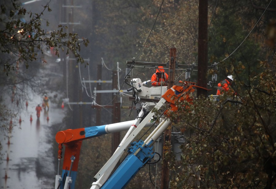 Pacific Gas and Electric crews repair power lines in Paradise that were destroyed by the Camp Fire, Nov. 21, 2018. (Credit: Justin Sullivan / Getty Images)