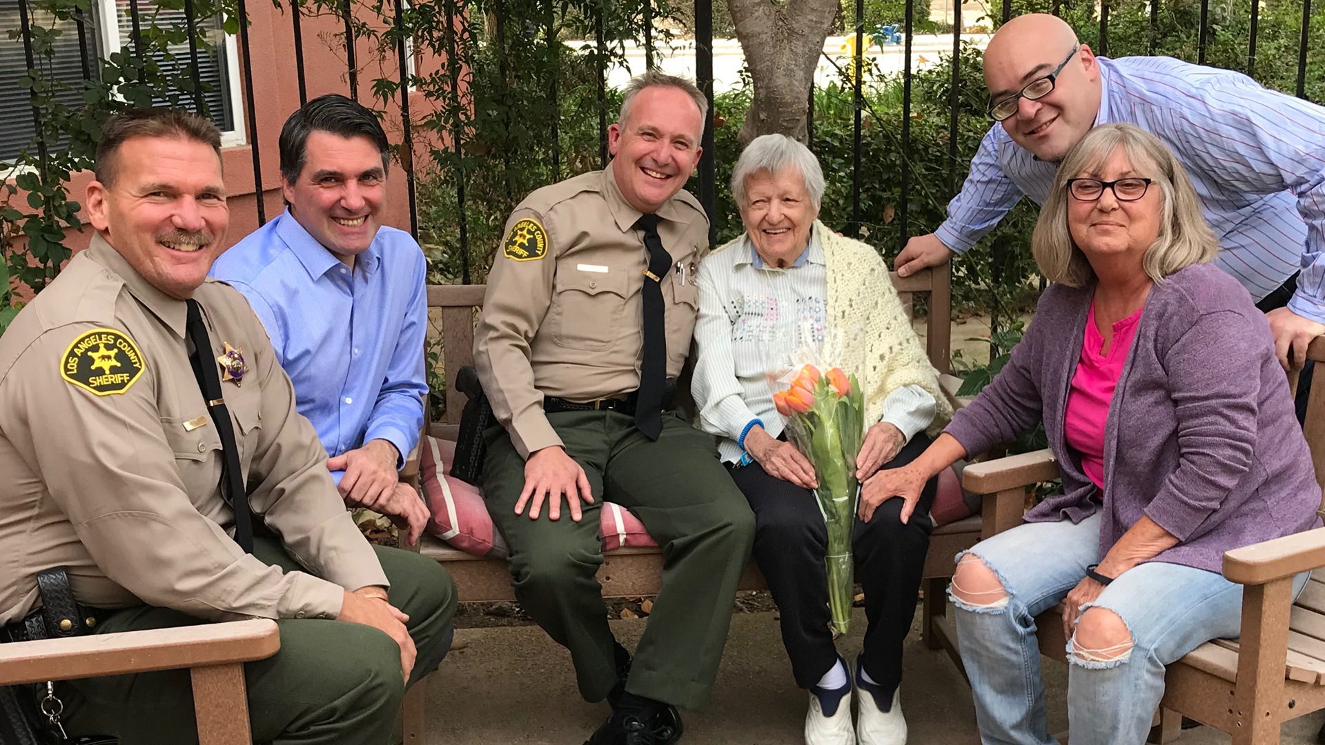 Ruth Cook, center, poses with L.A. County Sheriff's Department deputies Michael Rogers and Tom Henzgen at AlmaVia of Camarillo on Nov. 27, 2018. (Credit: KTLA)