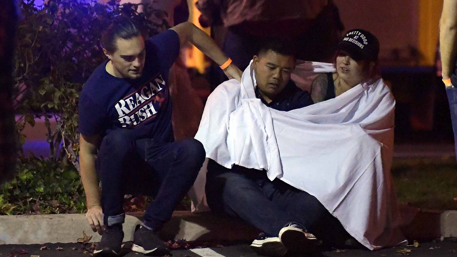 People comfort each near the scene Thursday, Nov. 8, 2018, in Thousand Oaks. (Credit: :Mark J Terrill / AP)