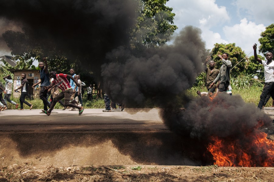 Protesters walk near the electoral commission in Beni during a demonstration against the postponement of elections in the territory of the Beni and the city of Butembo on Dec. 27, 2018. (Credit: ALEXIS HUGUET/AFP/Getty Images)