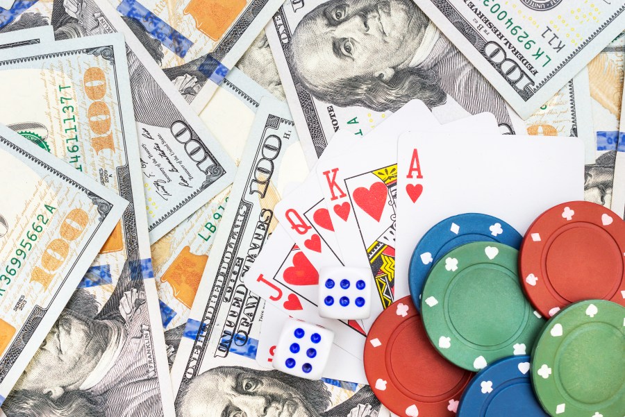 A file photo of dice, poker chips, playing cards and cash. (Credit: iStock / Getty Images Plus)