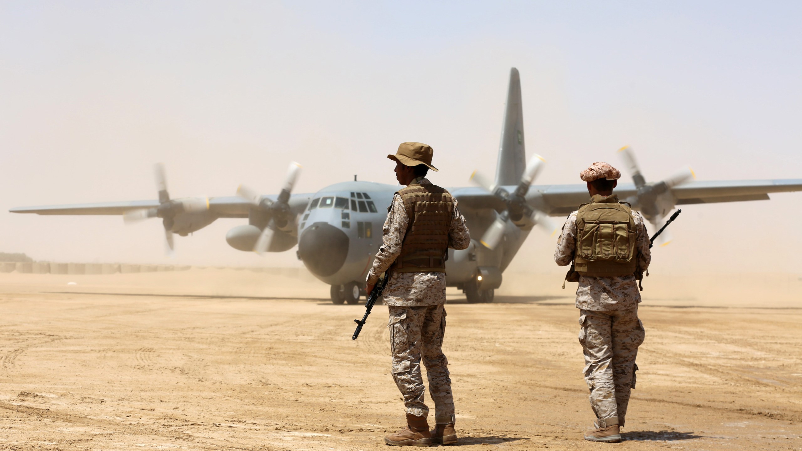 Saudi soldiers stand guard before aid supplies are unloaded from a Saudi air force cargo plane at an airfield in Yemen's central province of Marib, on March 12, 2018.( Credit: Abdullah Al-Qadry/AFP/Getty Images)