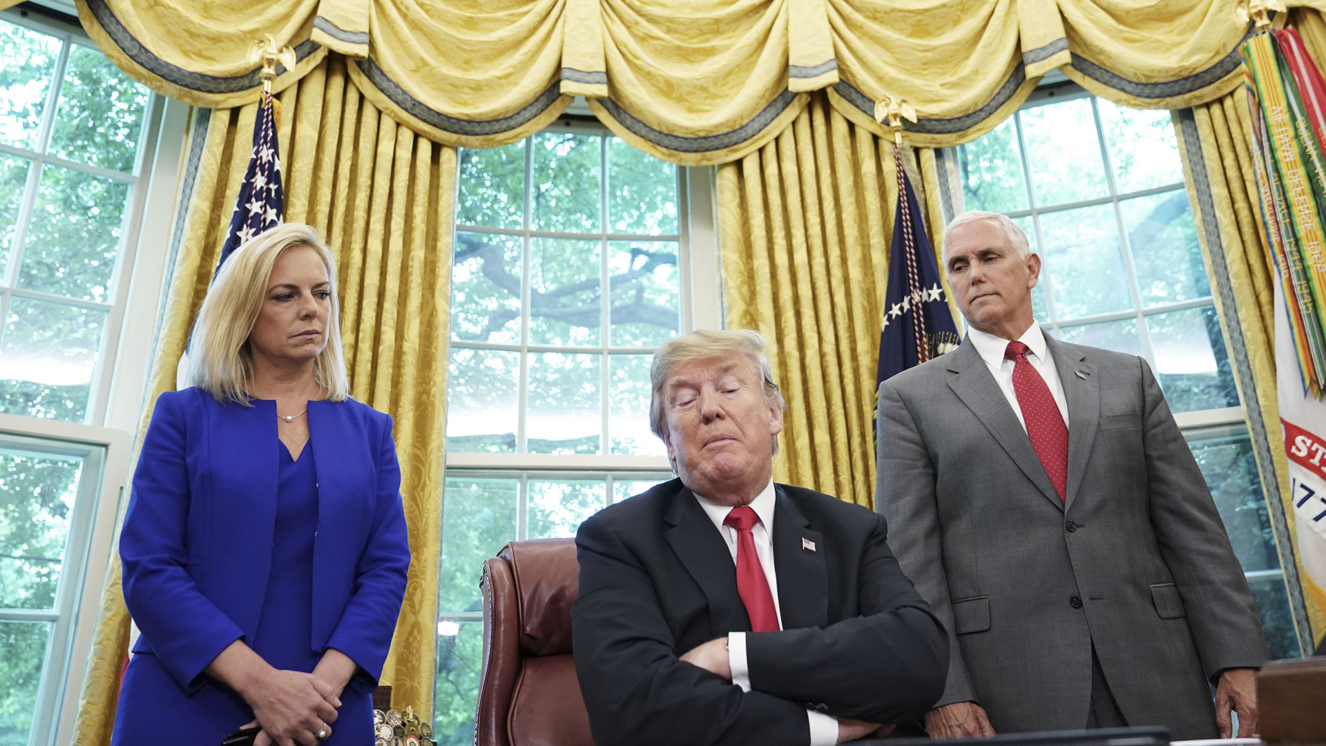 Watched by Homeland Security Secretary Kirstjen Nielsen (L) and Vice President Mike Pence, US President Donald Trump signs an executive order on immigration in the Oval Office of the White House on June 20, 2018 in Washington, DC. - US President Donald Trump on Wednesday signed an executive order aimed at putting an end to the controversial separation of migrant families at the border, reversing a harsh practice that had earned international scorn."It's about keeping families together," Trump said at the signing ceremony. "I did not like the sight of families being separated," he added. (Photo by Mandel Ngan / AFP) (Photo credit should read MANDEL NGAN/AFP/Getty Images)