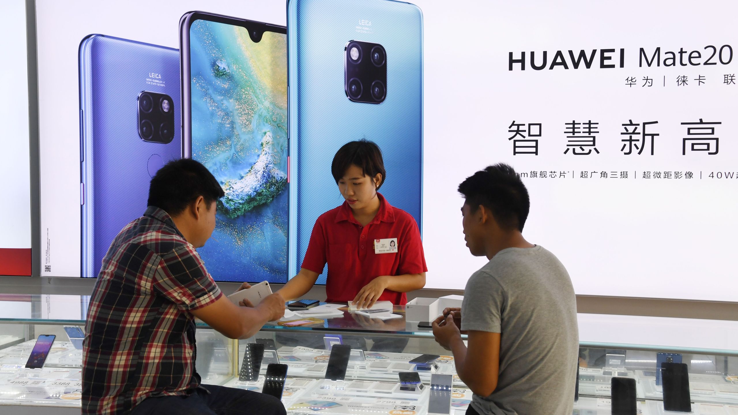 Customers are served at a Huawei stand in a store in Sanya on China's tropical Hainan Island on December 8, 2018.(Credit: Greg Baker/AFPGetty Images)