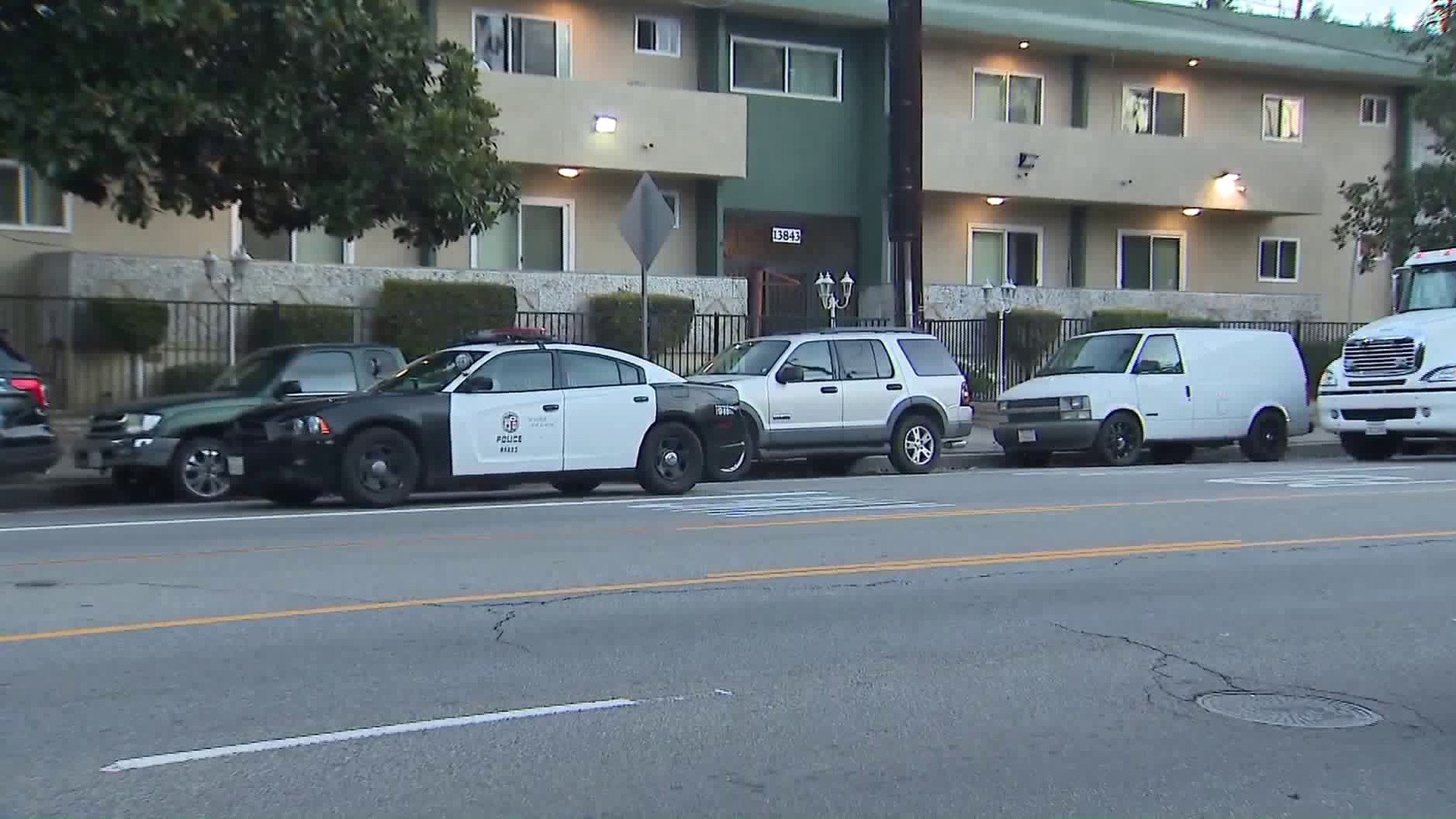 An LAPD cruiser sits outside an apartment complex in Valley Glen during a homicide investigation on Dec. 27, 2018. (Credit: KTLA)