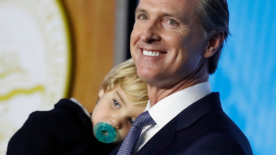 Gov. Gavin Newsom carries his 2-year-old son Dutch while delivering his inaugural address after being sworn in as the 40th governor of California on Jan. 7, 2019, in Sacramento. (Credit: Stephen Lam/Getty Images)