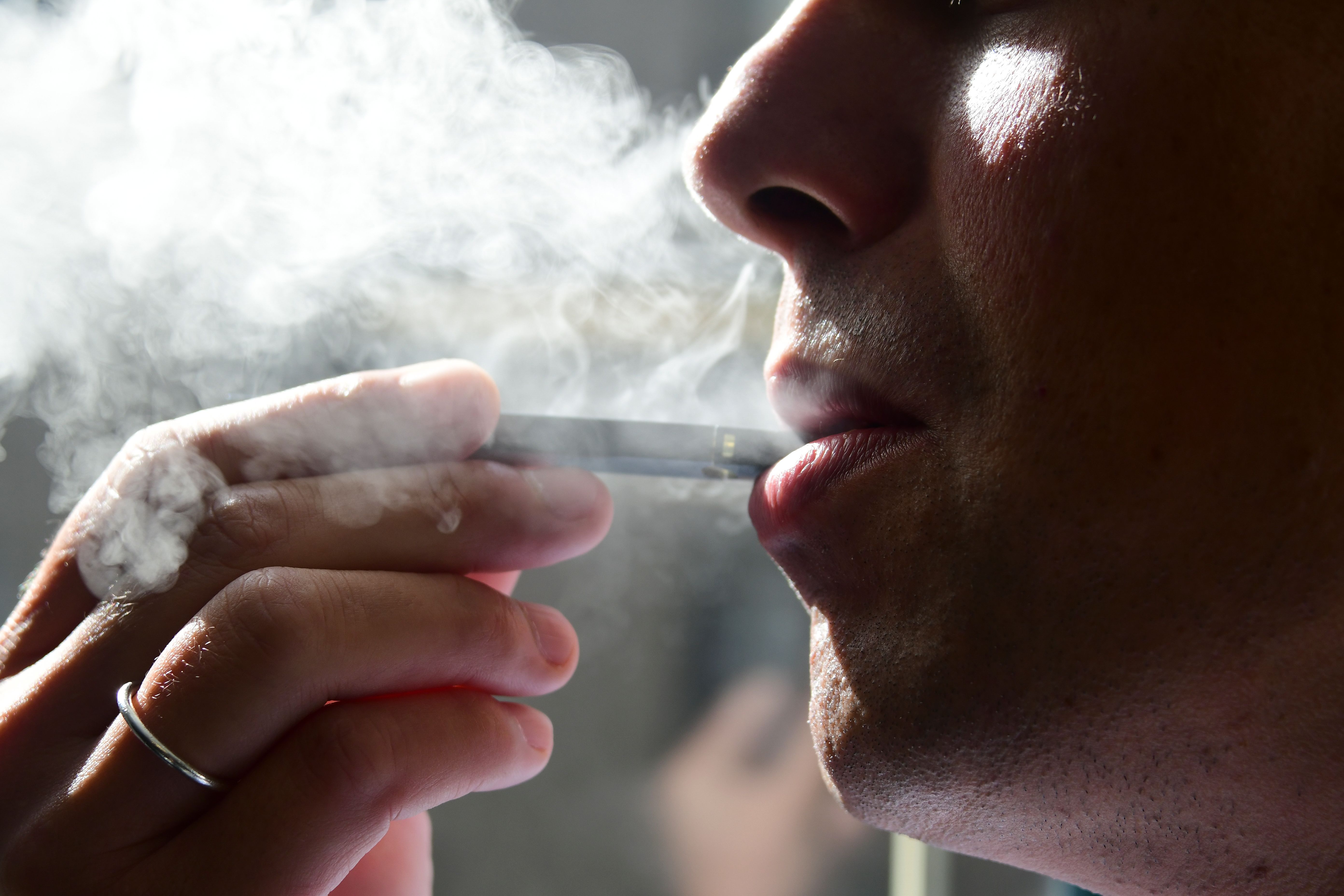 An image shows a man exhaling smoke from an e-cigarette in Washington, D.C. on Oct. 2, 2018.(Credit: Eva Hambach/AFP/Getty Images)