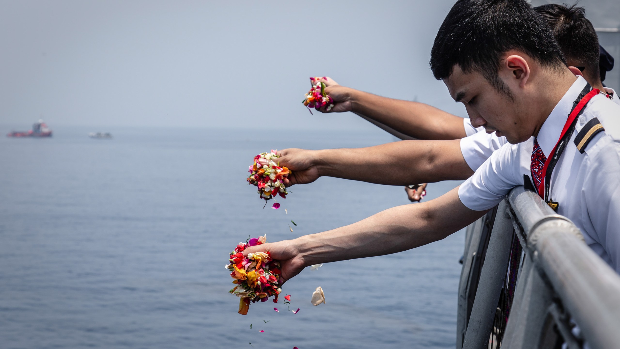 Colleagues of victims of Lion Air flight JT 610 throw flowers on deck of the Indonesian Navy ship KRI Banjarmasin during a visit to the crash site on November 6, 2018 in Karawang, Indonesia. (Credit: Ulet Ifansasti/Getty Images)