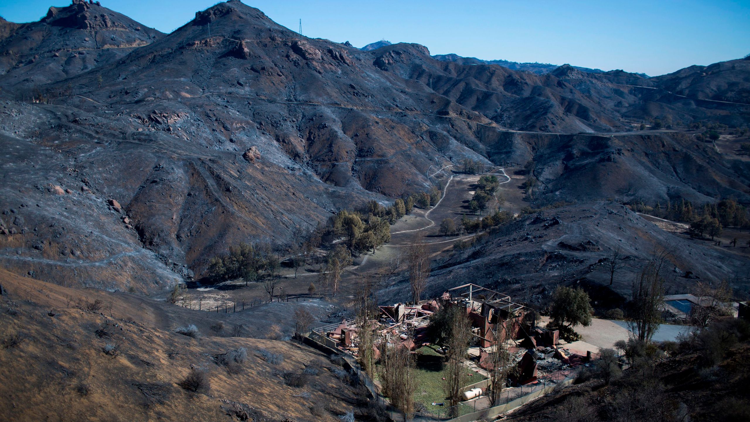 The Santa Monica Mountains are seen left blackened by the Woolsey Fire near Malibu on Nov. 14, 2018. (David McNew / AFP / Getty Images)