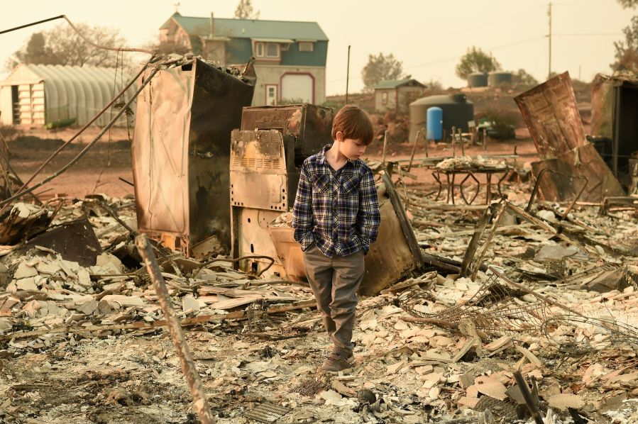 Jacob Saylors, 11, walks through the burned remains of his home in Paradise, Calif. on Nov. 18, 2018. The family lost a home in the same spot to a fire 10 years prior. (Credit: Josh Edelson / AFP) require. (Credit: JOSH EDELSON/AFP/Getty Images)