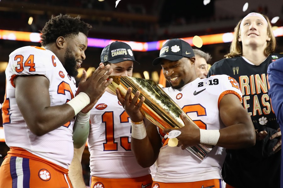 Kendall Joseph #34, Hunter Renfrow #13 and Adam Choice #26 of the Clemson Tigers celebrate with the trophy after their 44-16 win over the Alabama Crimson Tide in the CFP National Championship presented by AT&T at Levi's Stadium on January 7, 2019 in Santa Clara. (Credit: Ezra Shaw/Getty Images)