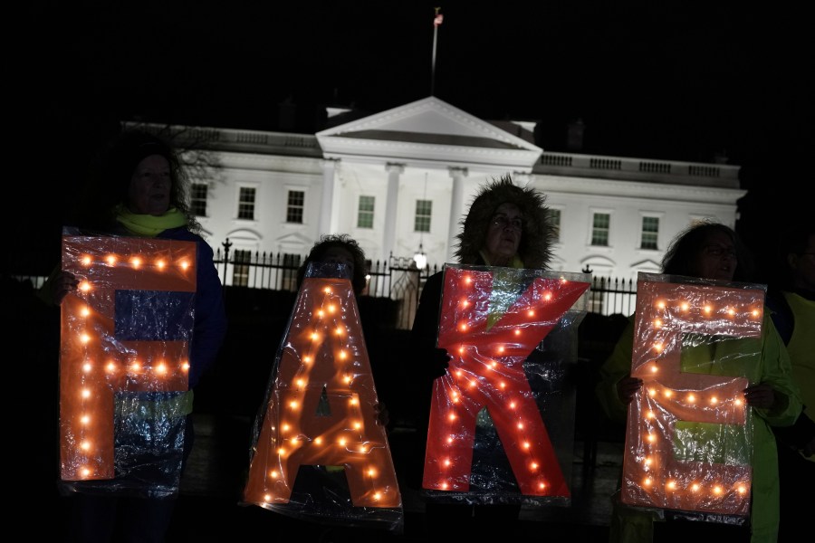 Activists hold a lit "FAKE" sign as they stage a protest outside the White House in response to U.S. President Donald Trump’s prime-time address to the nation on Jan. 8, 2019. (Credit: Alex Wong / Getty Images)