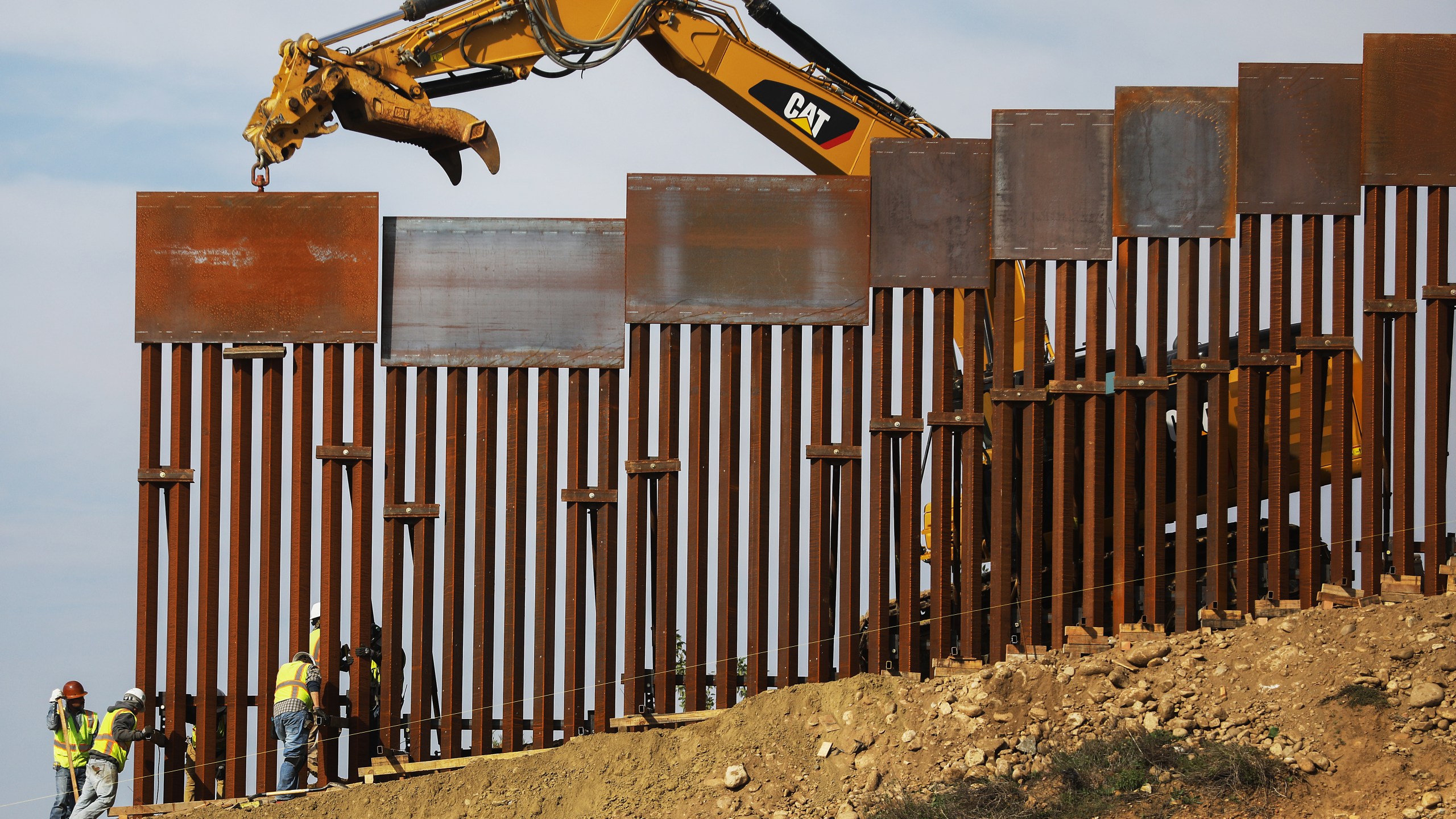 A construction crew installs new sections of the U.S.-Mexico border barrier replacing smaller fences on January 11, 2019 as seen from Tijuana, Mexico.. (Credit: Mario Tama/Getty Images)