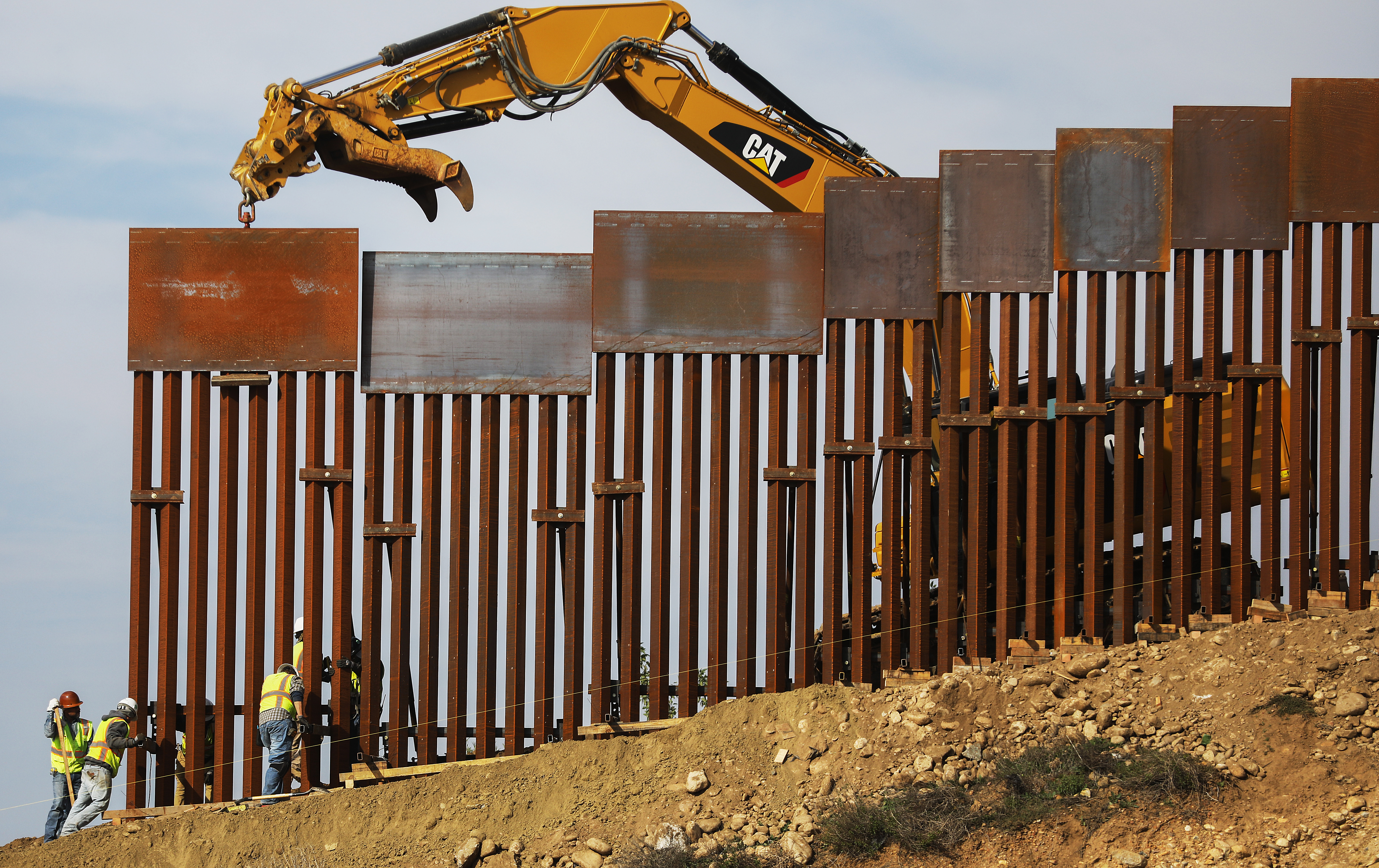 A construction crew installs new sections of the U.S.-Mexico border barrier replacing smaller fences on January 11, 2019 as seen from Tijuana, Mexico.. (Credit: Mario Tama/Getty Images)