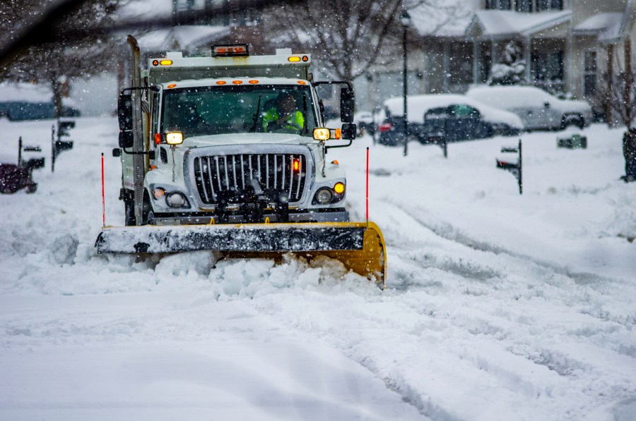 File photo of heavy equipment driver working to push snow to the side of the streets after a blizzard. (Credit: Getty Images)