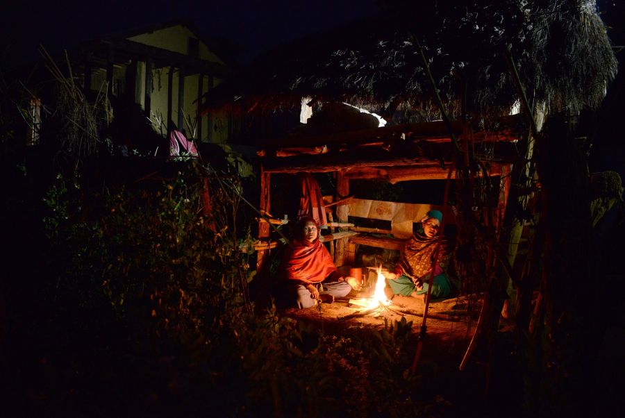 In this photograph taken on February 3, 2017, Nepalese women Pabitra Giri (L) and Yum Kumari Giri (R) sit by a fire as they live in a Chhaupadi hut during their menstruation period in Surkhet District, some 520km west of Kathmandu. The practice of banning women from the home when they are menstruating is linked to Hinduism and considers women untouchable at this time. They are banished from the home -- barred from touching food, religious icons, cattle and men -- and forced into a monthly exile sleeping in basic huts. (Credit: PRAKASH MATHEMA/AFP/Getty Images)