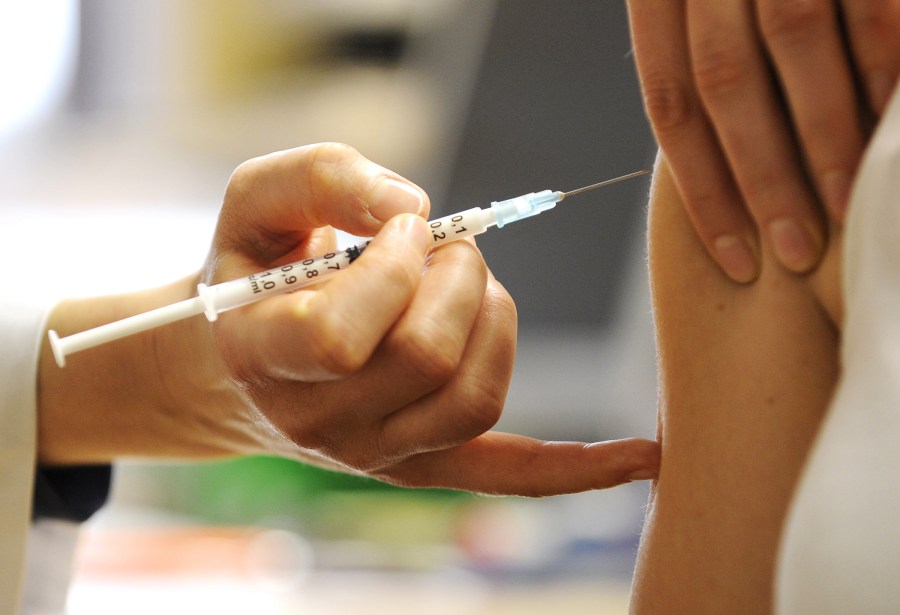 A woman receives a vaccine in this file photo. (Credit: Norbert Millauer / AFP / Getty Images)