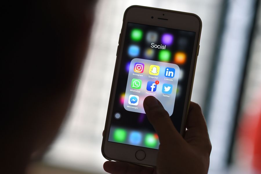 This photo illustration taken on March 22, 2018, shows a woman looking at social networking applications Facebook, Instagram, Snapchat, WhatsApp, Twitter, Messenger and LinkedIn on a smartphone in Kuala Lumpur. (Credit: MANAN VATSYAYANA/AFP/Getty Images)